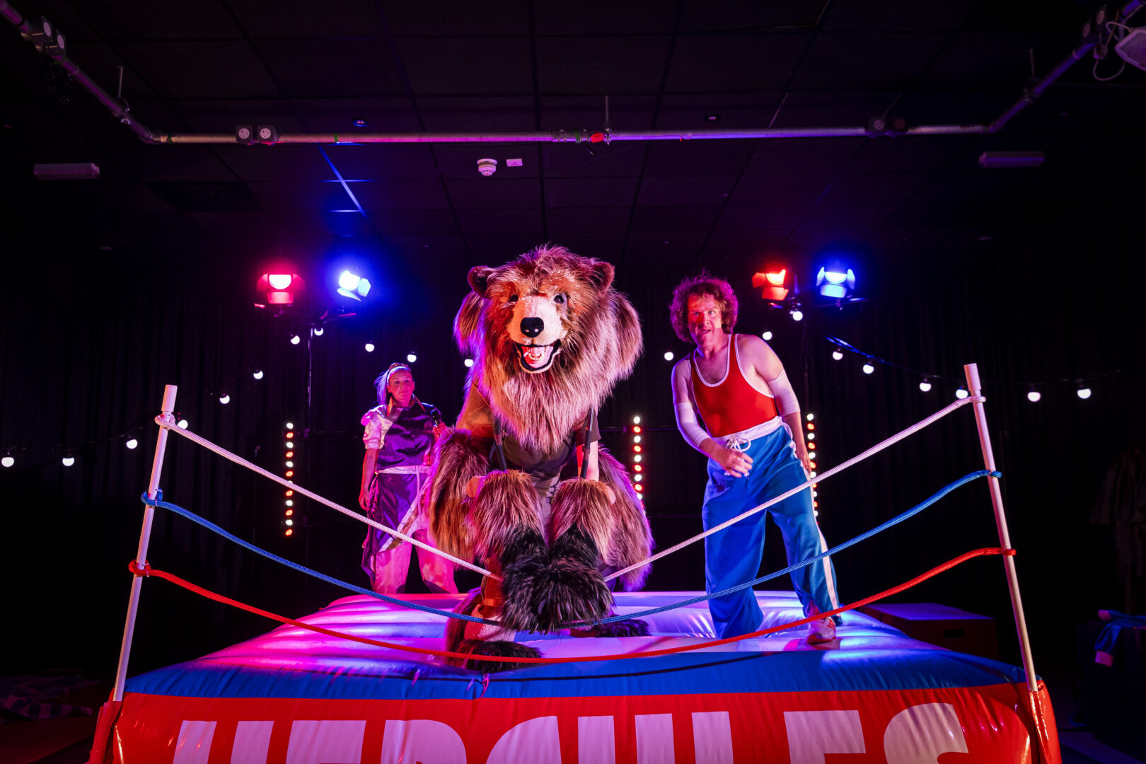 A fake bear and a man in a wrestling/boxing sqaure