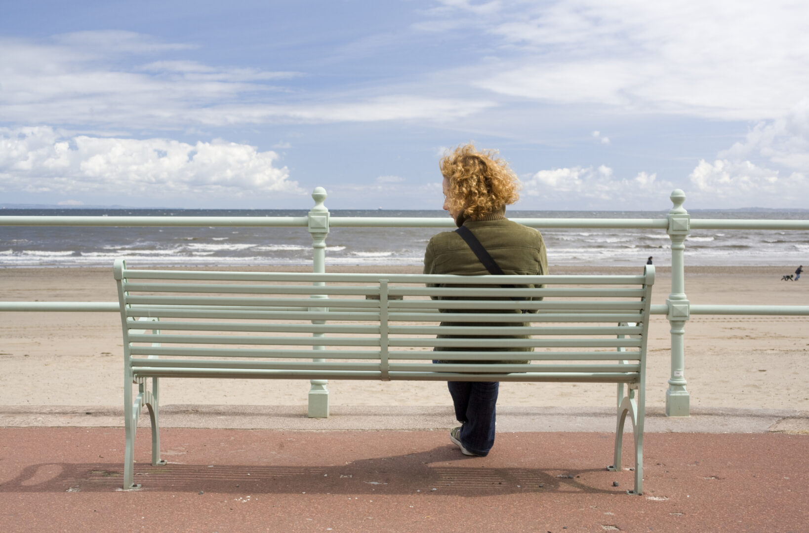 Young woman looking at something along the sea front, at Portobello, Edinburgh, Scotland.